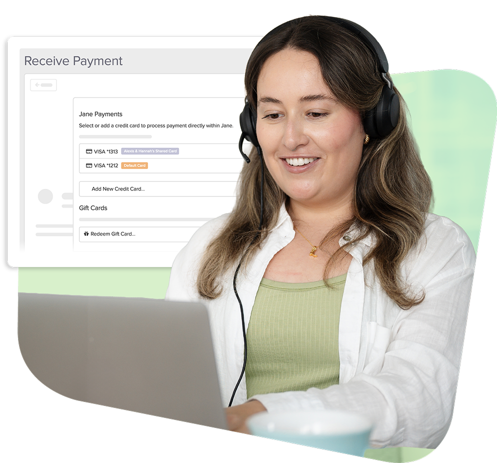 Customer service representative wearing headset at laptop with payment processing interface showing credit card and gift card options