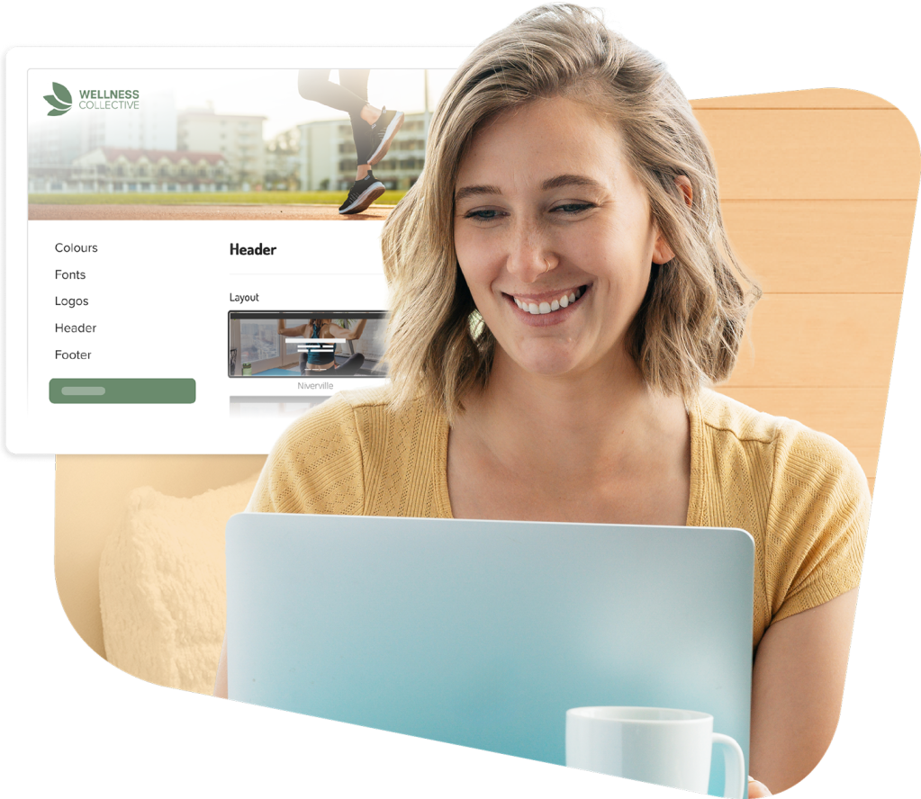 Woman smiling while working on laptop with website design interface visible on screen