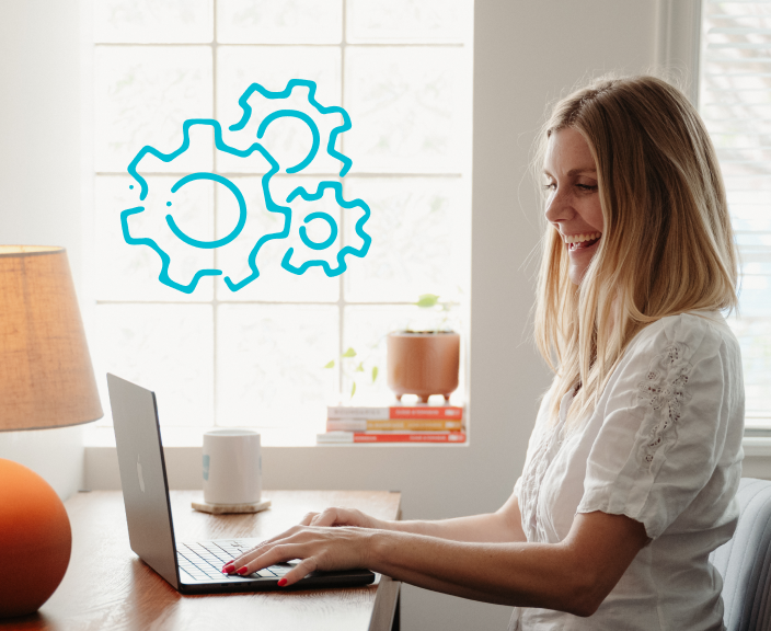 Woman working on laptop with gear icons representing workflow or process optimization