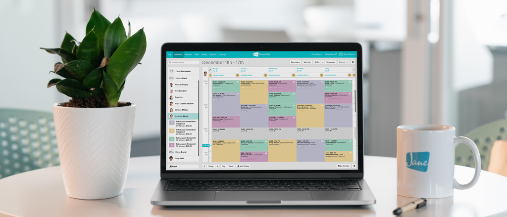 Laptop displaying a colorful weekly calendar interface with scheduled appointments and team member list on the left sidebar