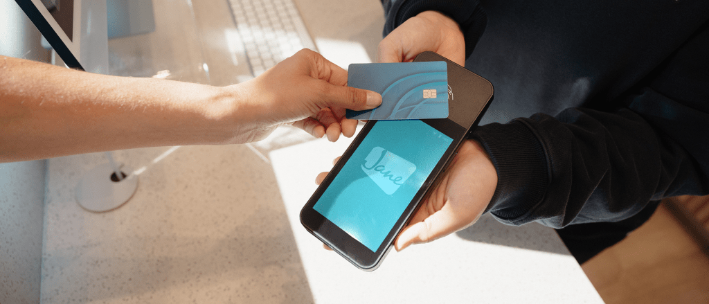 Customer making contactless payment by tapping credit card on mobile payment terminal