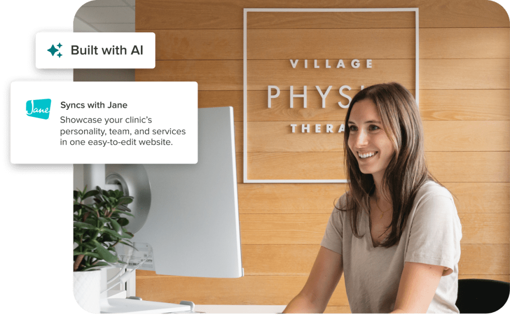 Smiling woman at reception desk in modern physical therapy clinic with wood-paneled wall displaying Village Physio Therapy sign