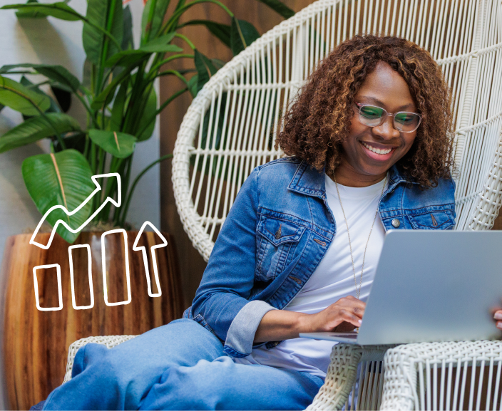 Woman smiling while working on a laptop, with a graphic of an upward growth chart beside her