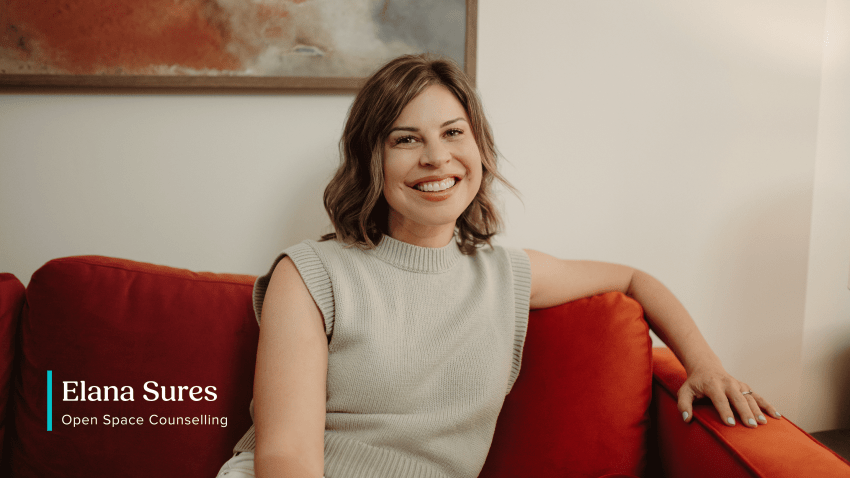 Elana Sures of Open Space Counselling smiling, seated on a red couch