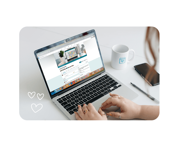 Person typing on a laptop showing a webpage, with a coffee mug and phone on the desk nearby
